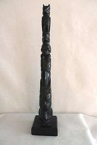  pole carved from black resin with 6 figures from top to bottom  