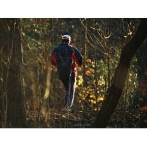 Jogger Running on Sun Dappled Trail Through Rock Creek Park Stretched 